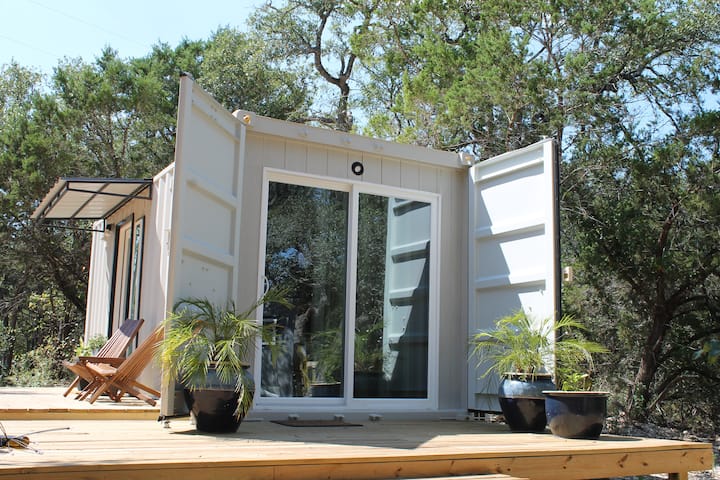 Sans Cedar container cabin among Texas oaks and cedar